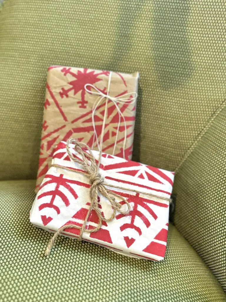 Two wrapped gifts with winter holiday themed paper