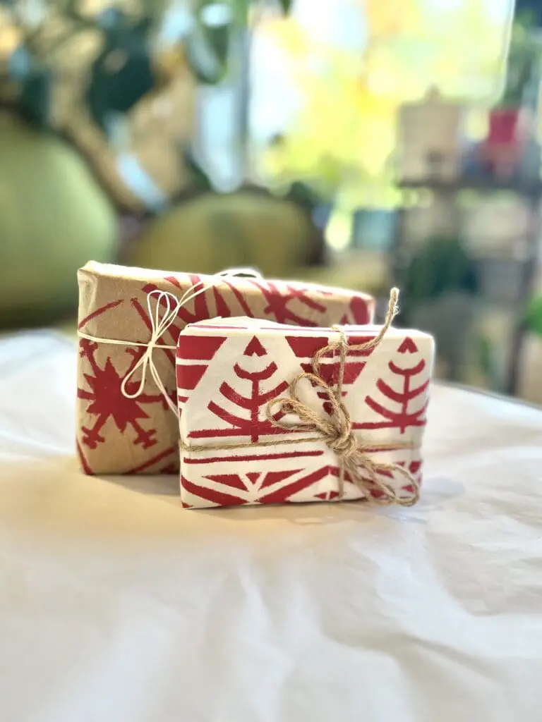 Two wrapped gifts with winter holiday themed paper
