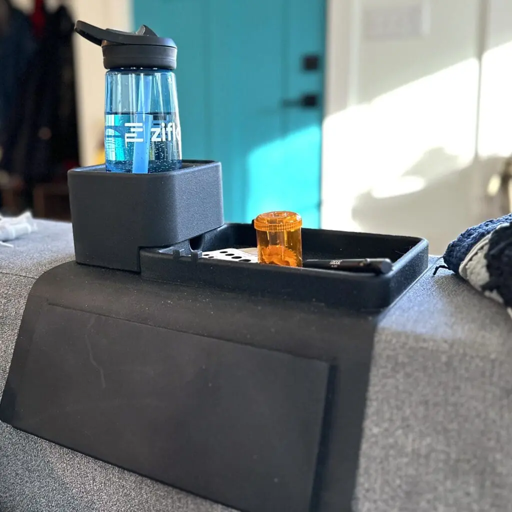 A black tray that fits over the arm of the couch